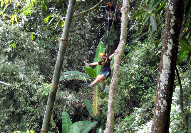 Megan flying on a zip line in Thailand