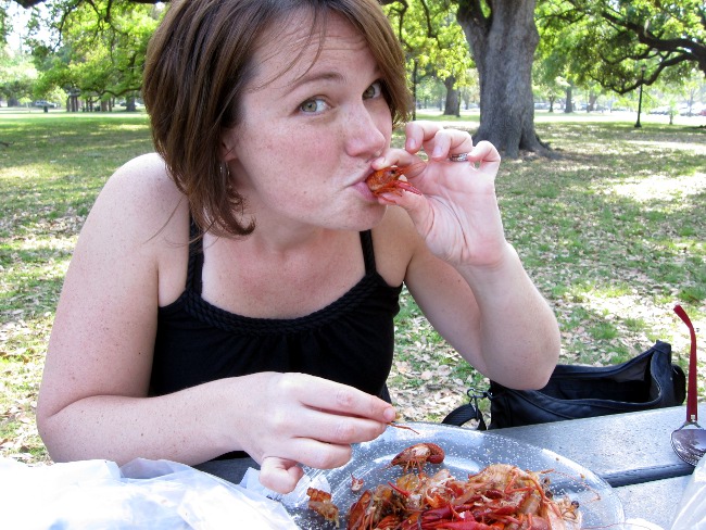 Megan sucking the head of a crawfish in Audubon Park, New Orleans